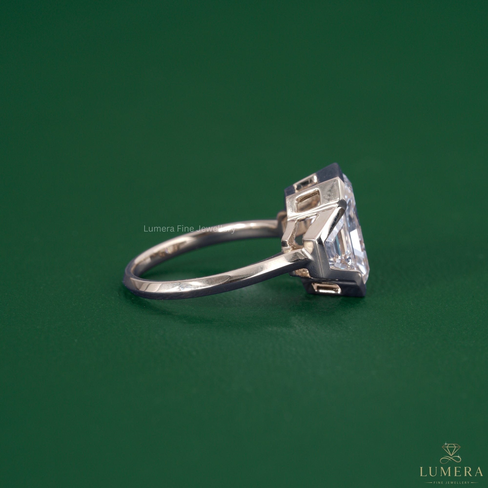 Trapezoid side stone set in a solid gold ring.