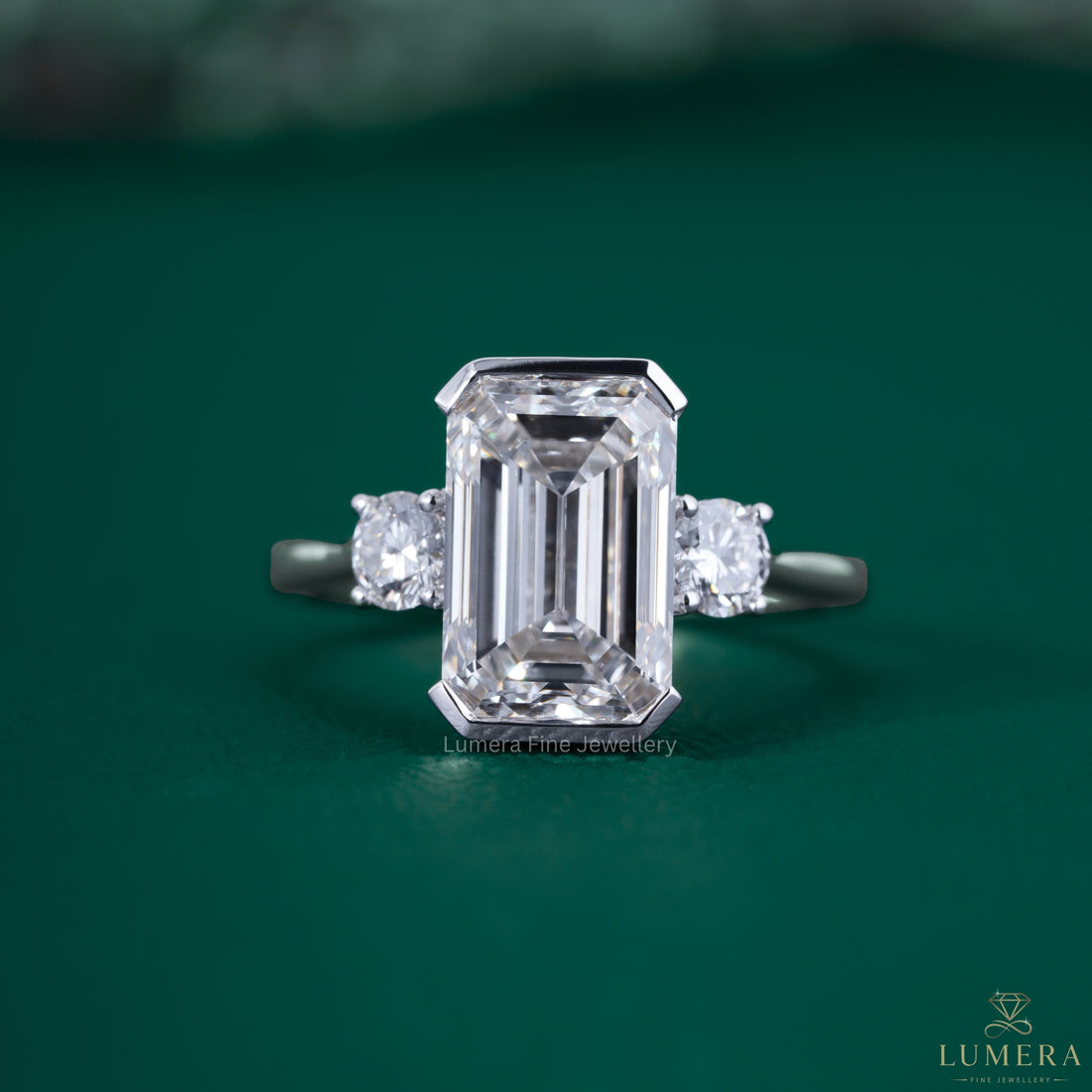 Half bezel engagement ring with emerald diamond engagement ring.
