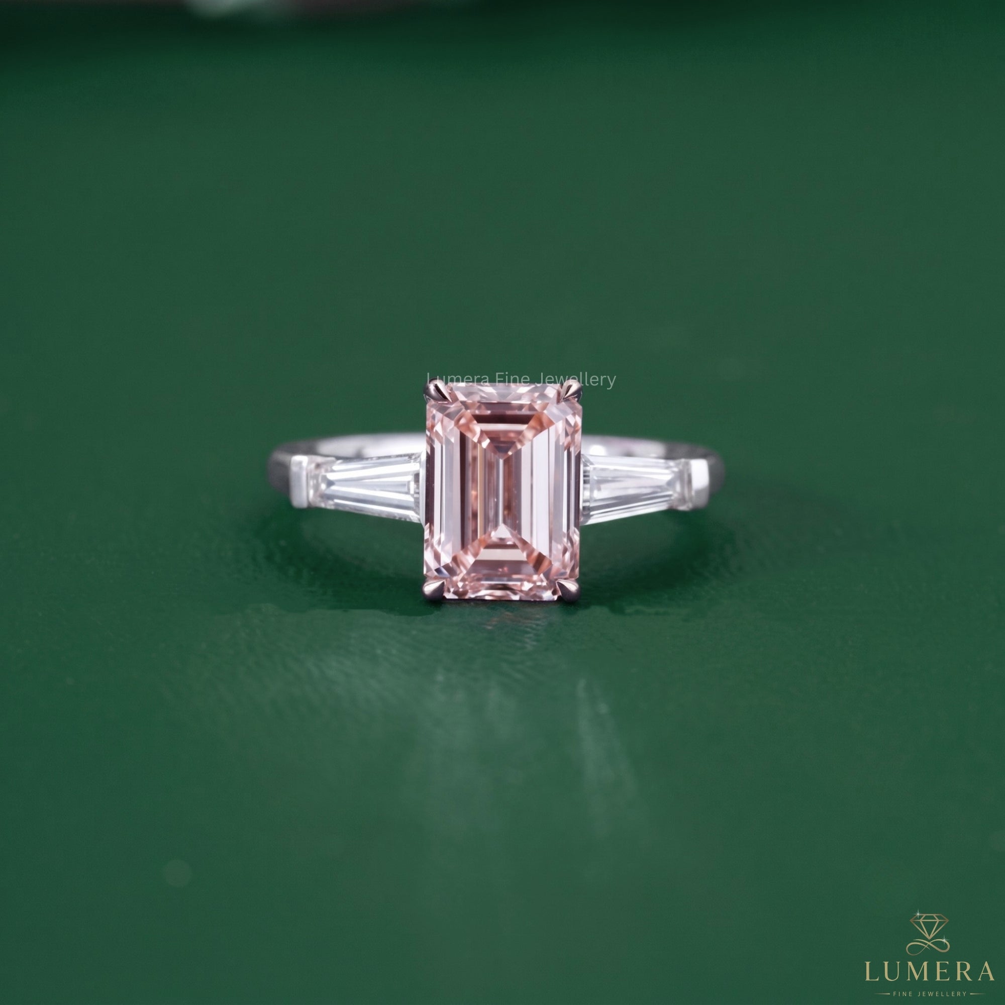 Emerald pink diamond ring featuring a three stone diamond ring.