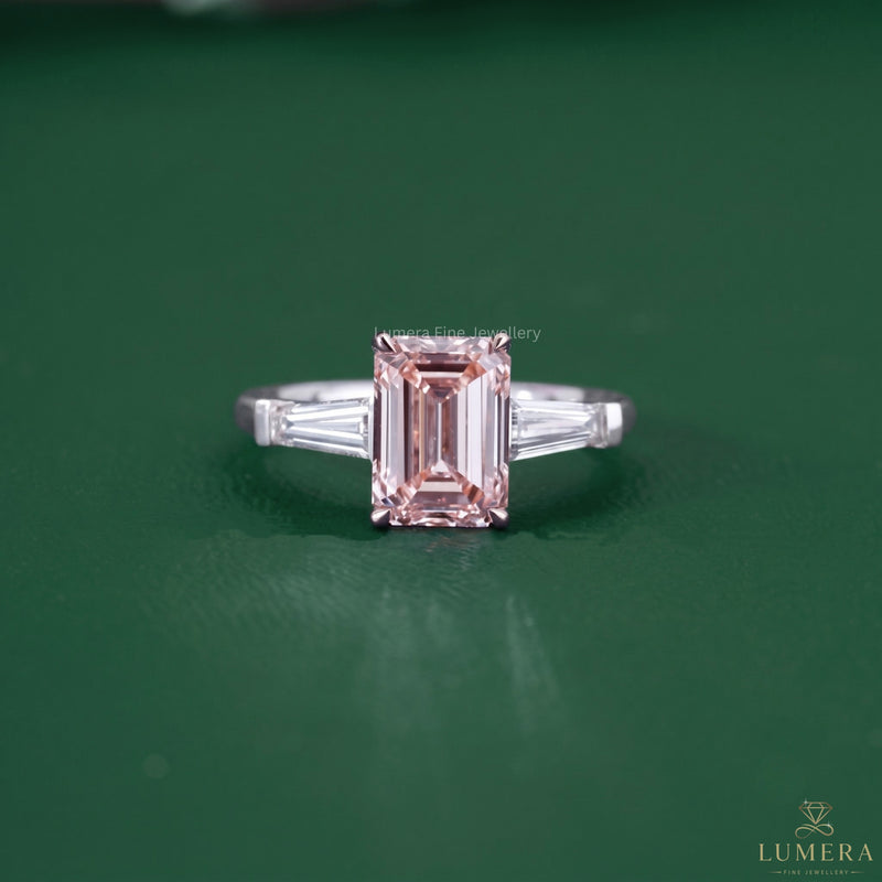 Emerald pink diamond ring featuring a three stone diamond ring.