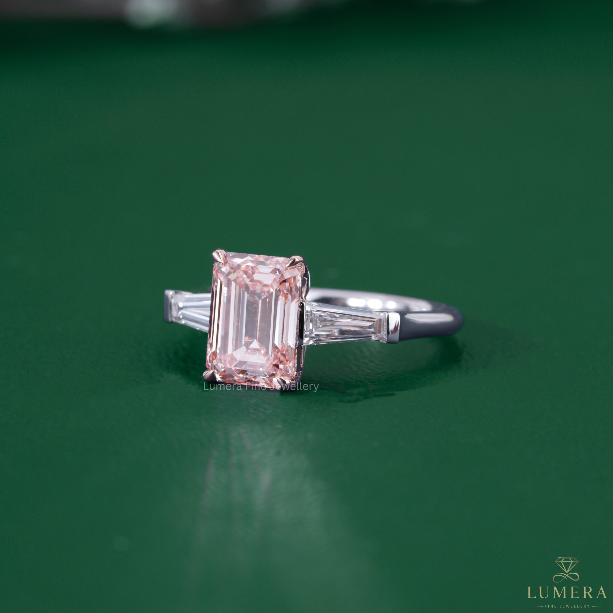 Emerald diamond engagement ring beside a basket setting ring