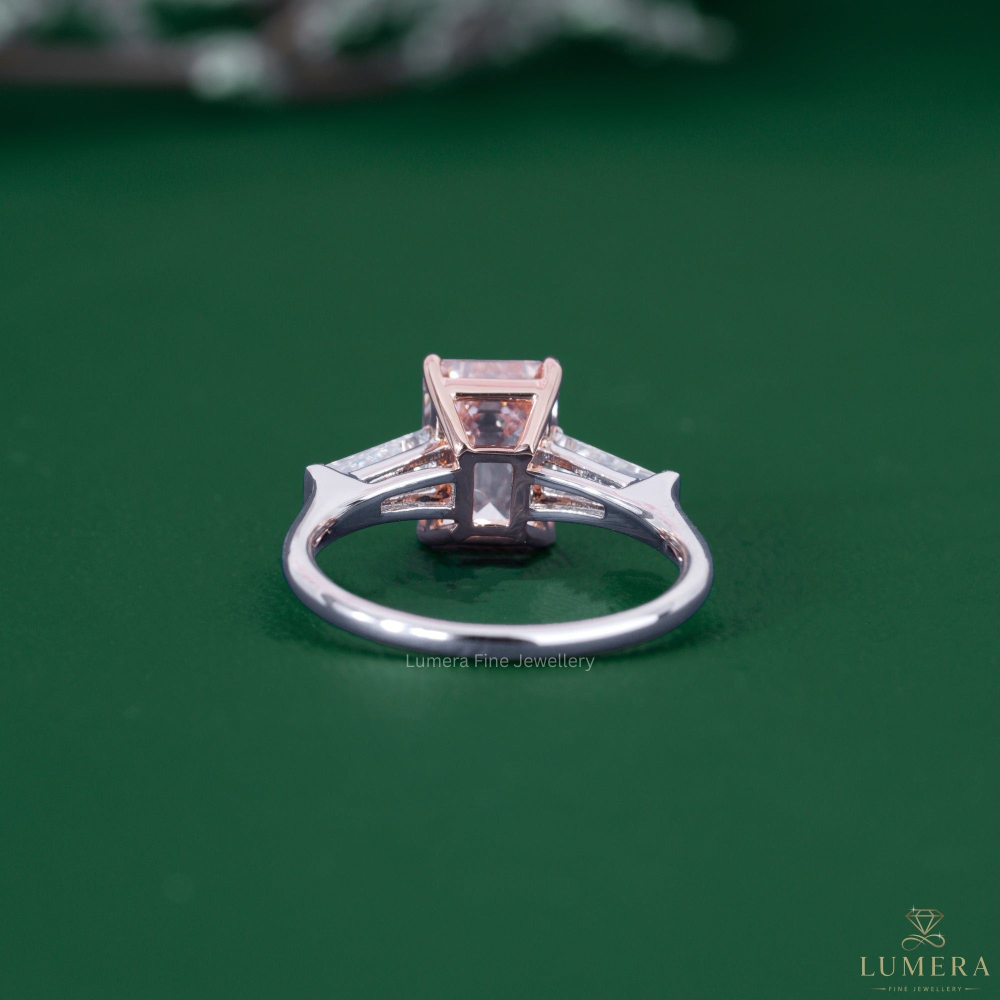 Emerald diamond ring featuring a tapered baguette side stone.