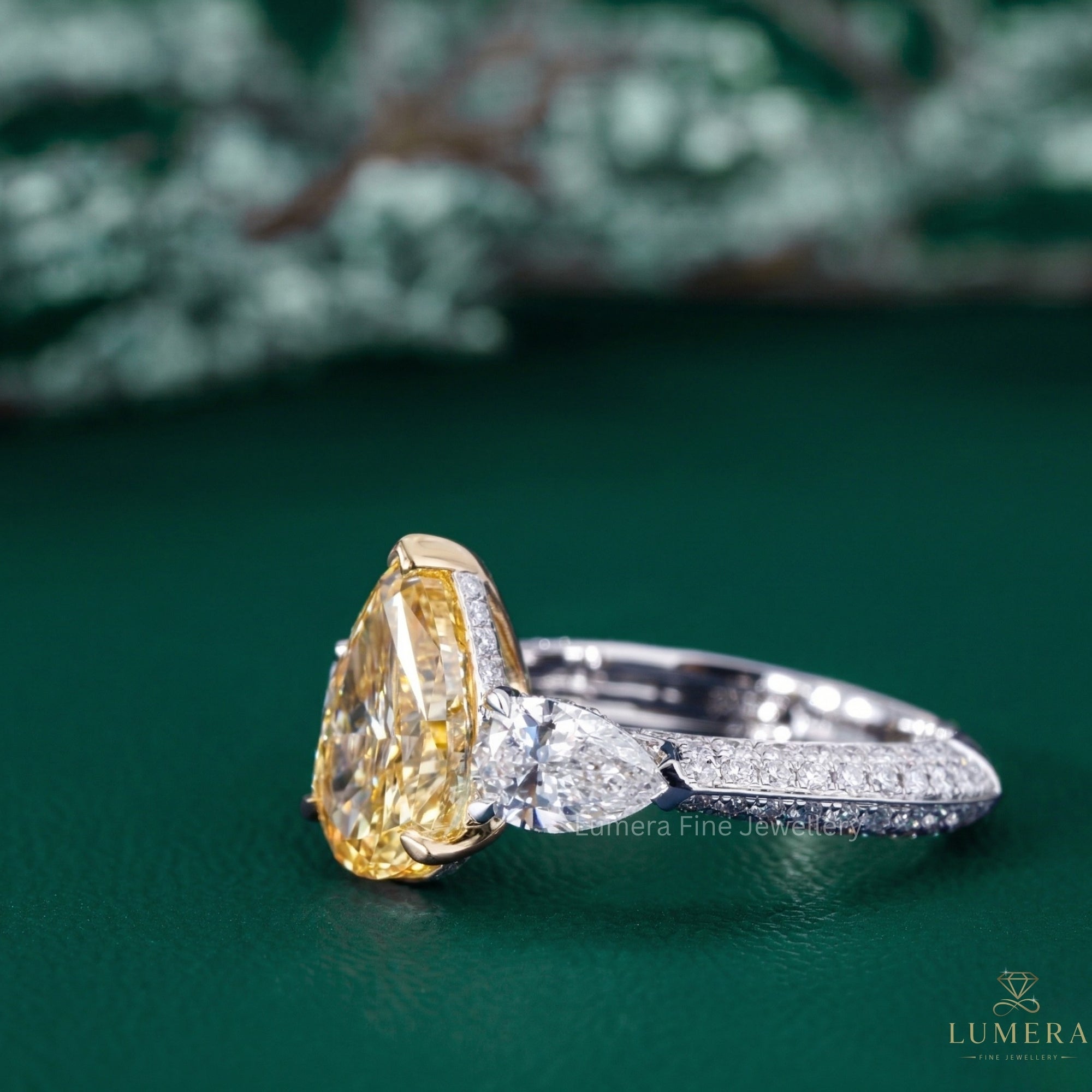 yellow diamond engagement ring with pear side stone.
