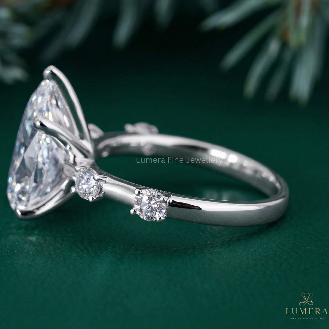 almond diamond ring with round cut side stones.