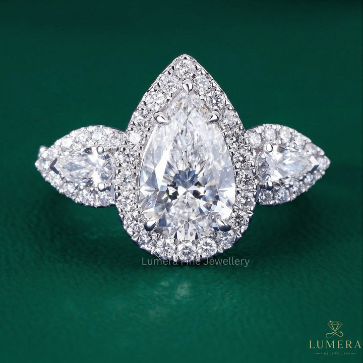 pear shaped three stone diamond ring with trellis setting ring.