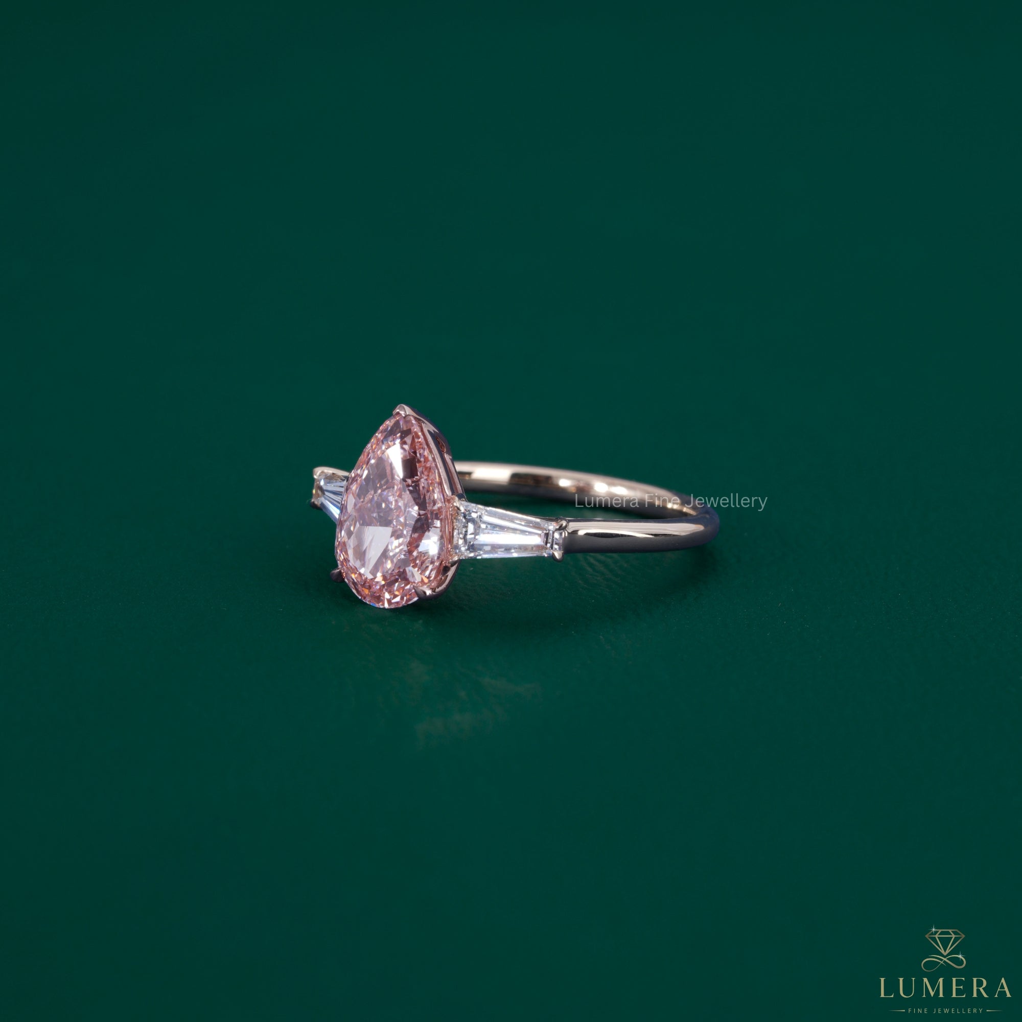 Pear diamond ring featuring tapered baguette diamonds.