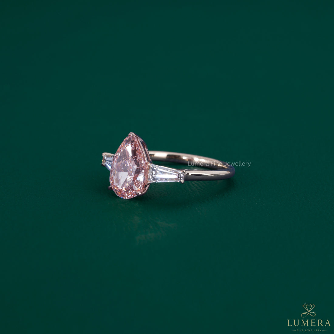 Pear diamond ring featuring tapered baguette diamonds.