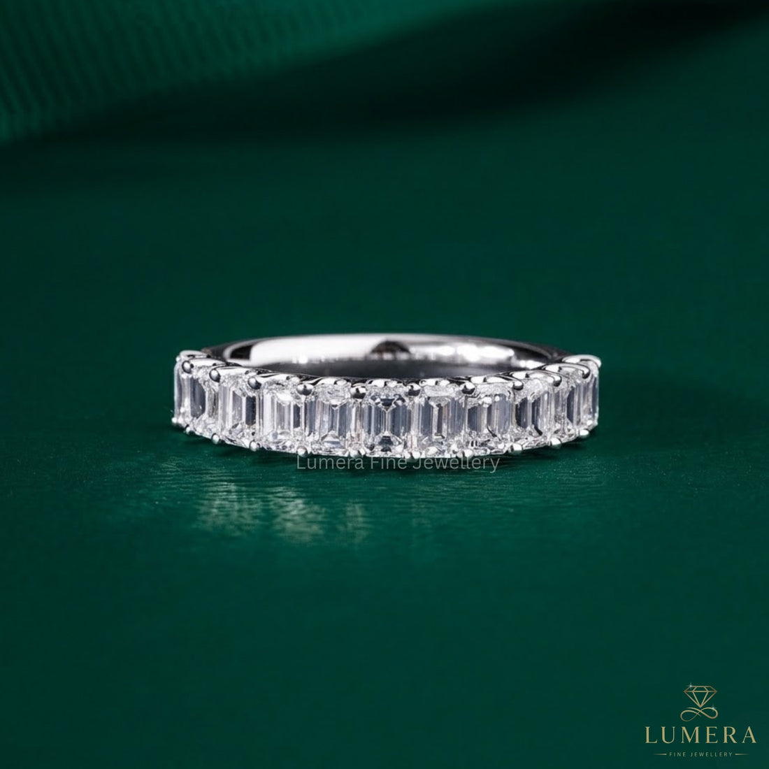 Emerald wedding band featuring a shared U prong band.
