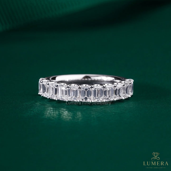 Emerald wedding band featuring a shared U prong band.
