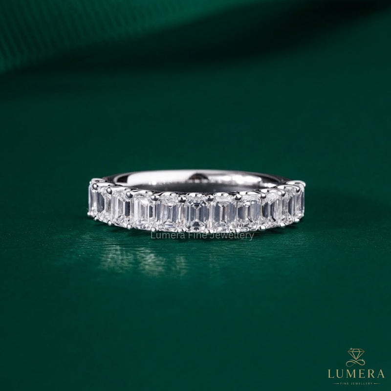 Emerald wedding band featuring a shared U prong band.

