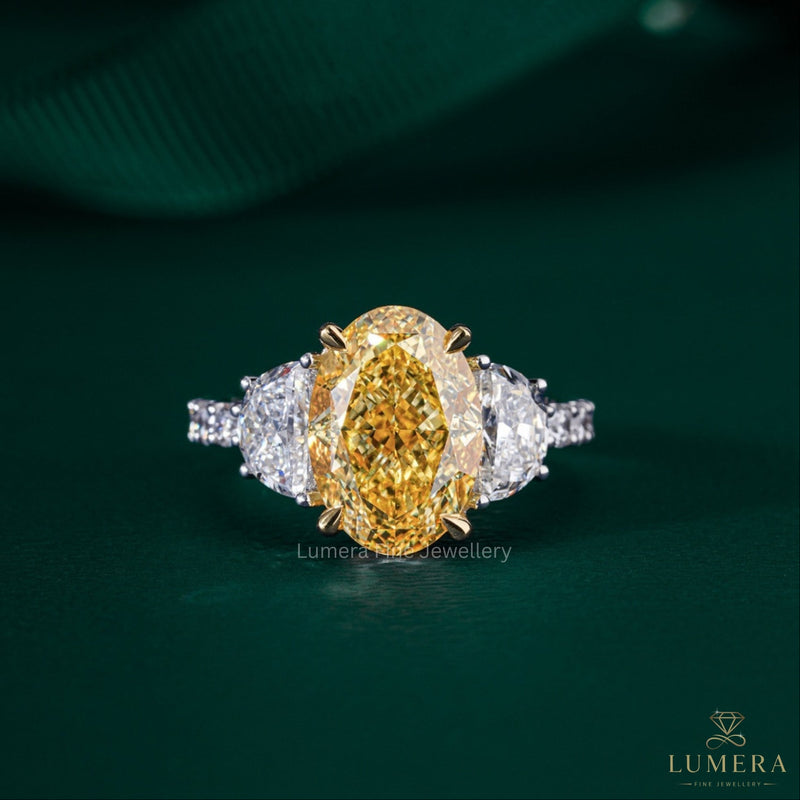 yellow oval diamond ring with half moon cut side stone.