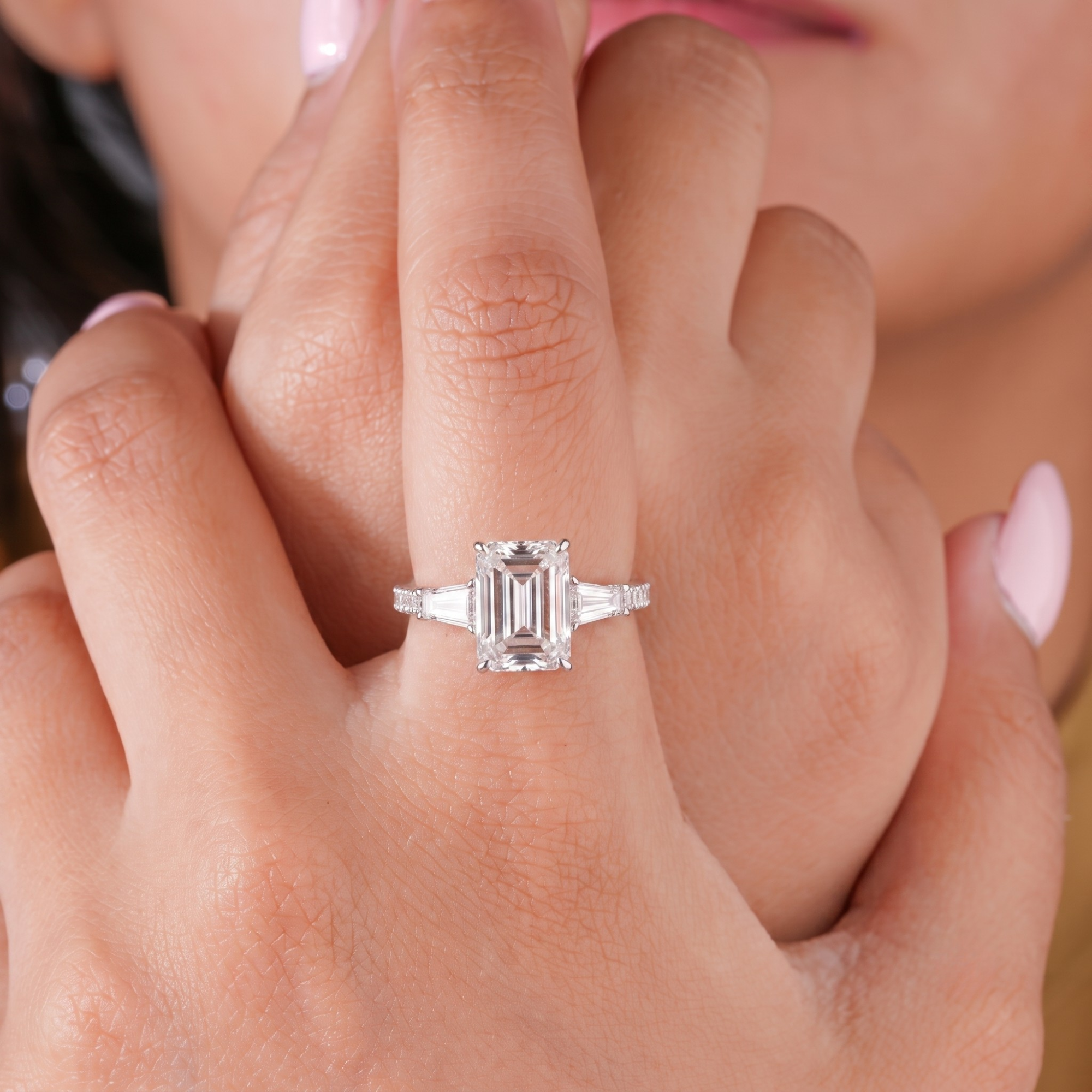 three stone emerald cut diamond ring with 3 side row pave band.
