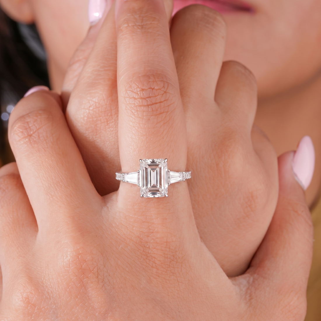 three stone emerald cut diamond ring with 3 side row pave band.
