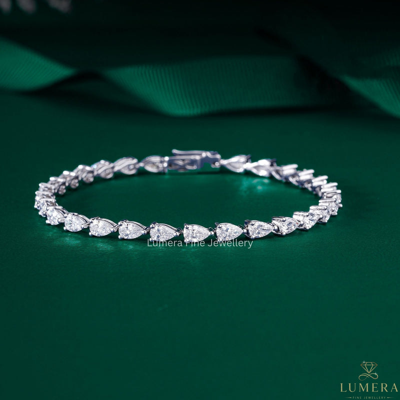 pear tennis bracelet with solid gold bracelet.