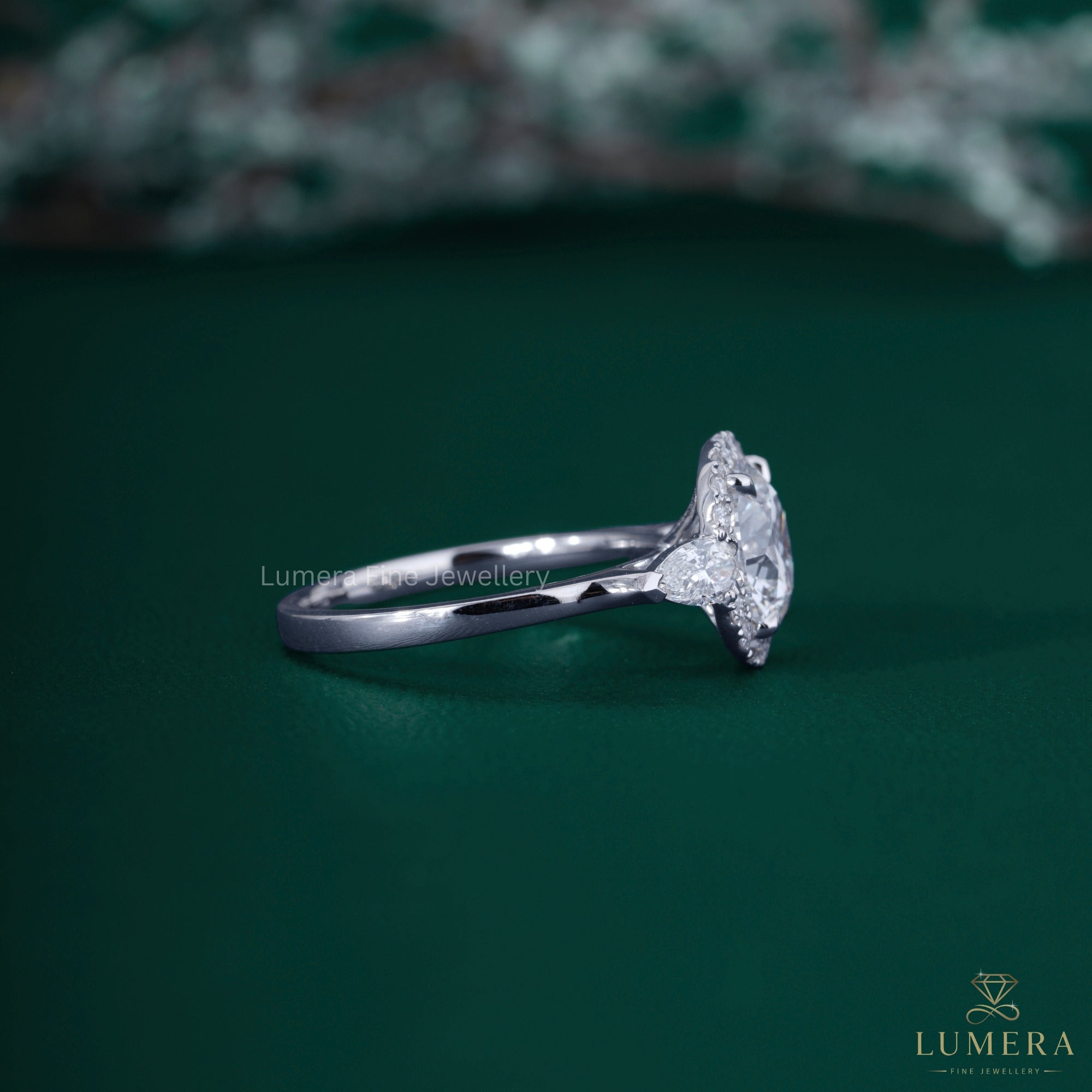 Halo diamond engagement ring with pear cut side stone.