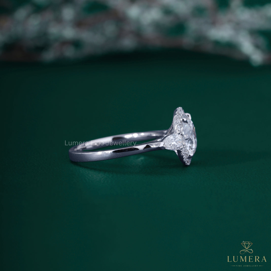 Halo diamond engagement ring with pear cut side stone.
