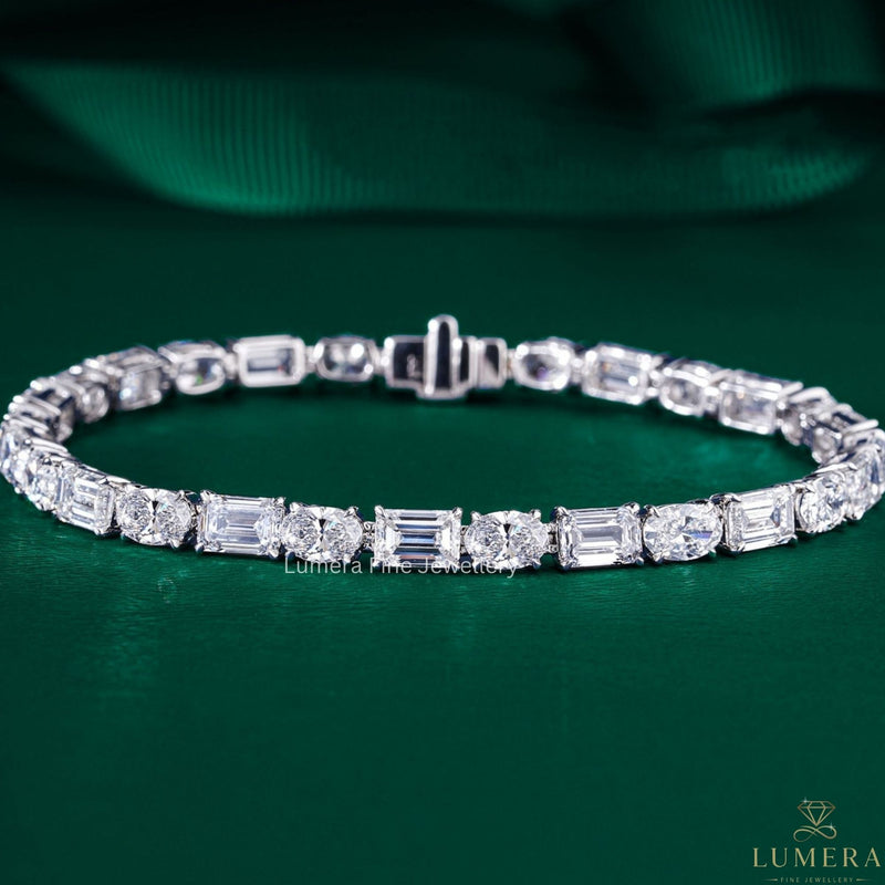 emerald tennis bracelet with gold oval link bracelet.