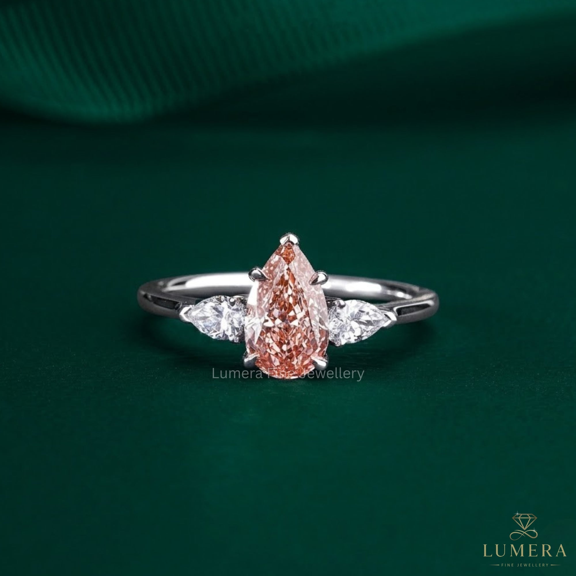 pink stone ring with pear cut three stone ring.
