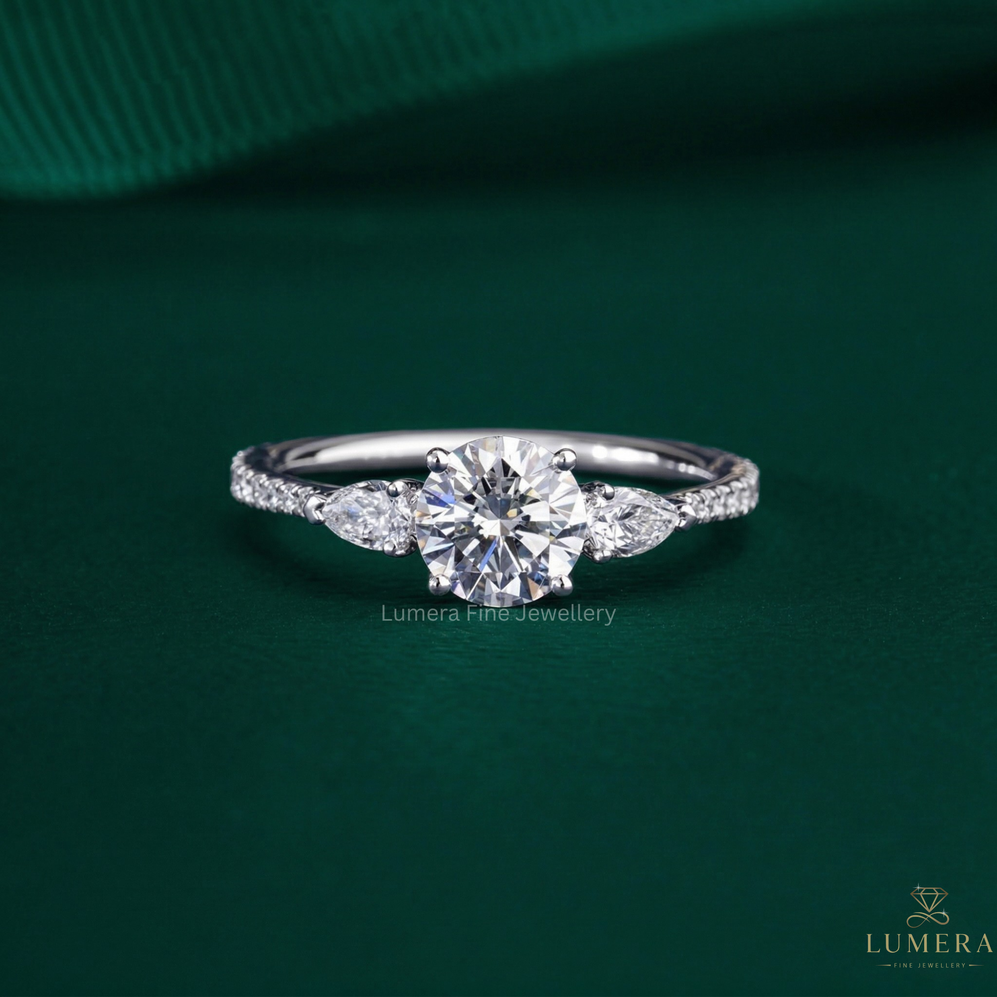 round cut engagement ring with pear side stone.
