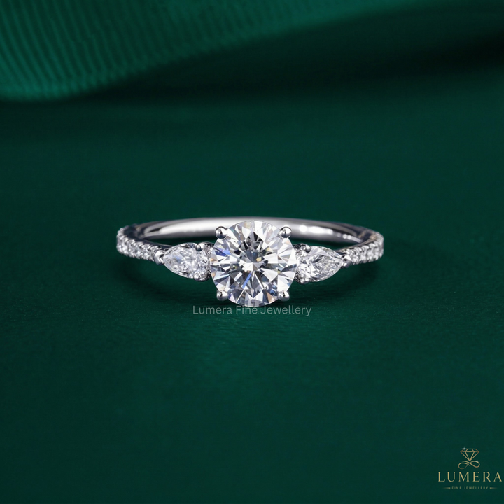 round cut engagement ring with pear side stone.
