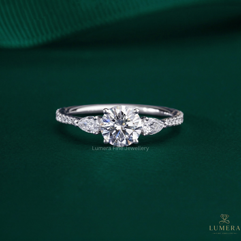 round cut engagement ring with pear side stone.
