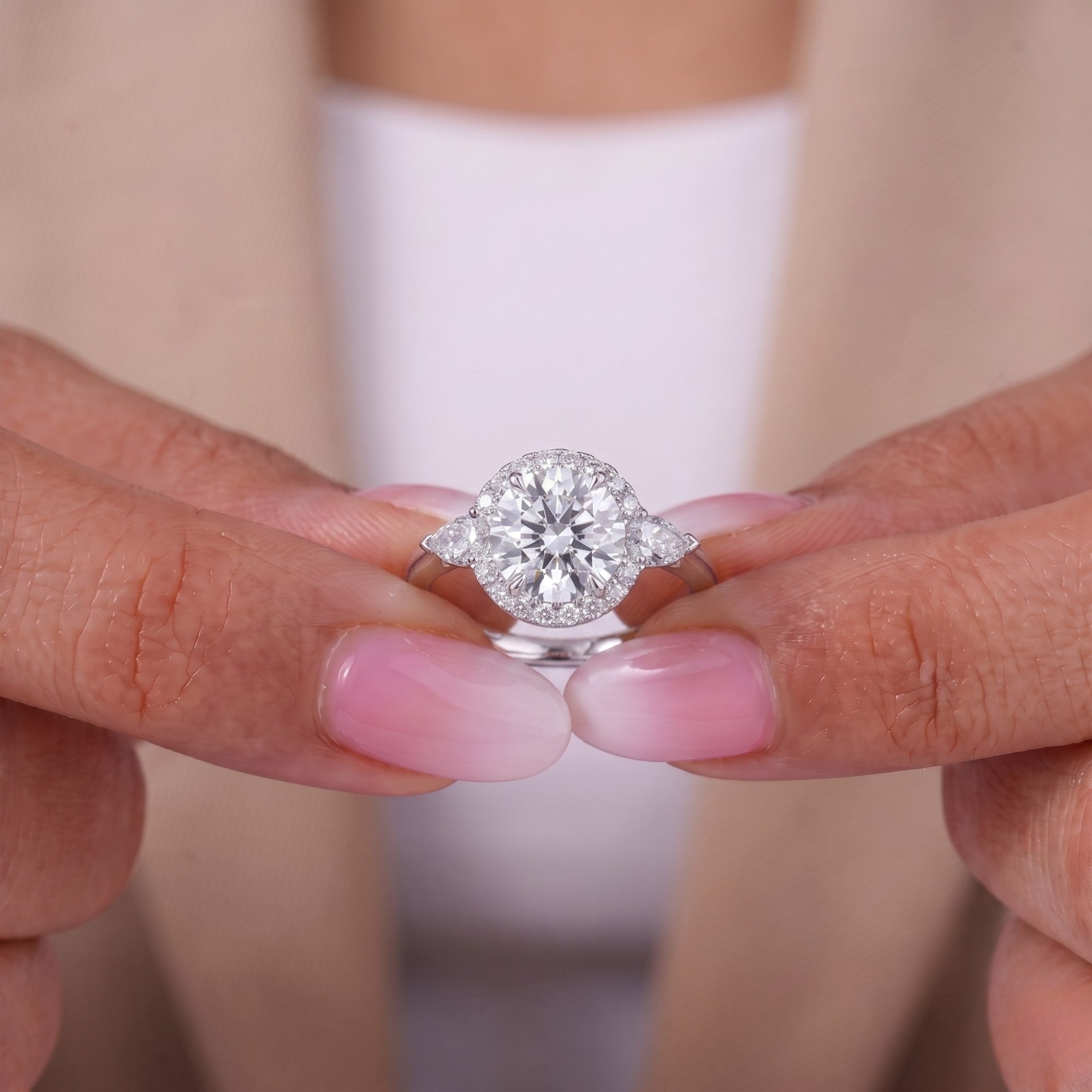 Round and pear diamond ring with halo engagement ring.
