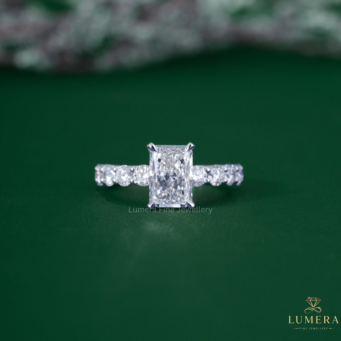 Radiant cut diamond engagement ring with pave setting ring.