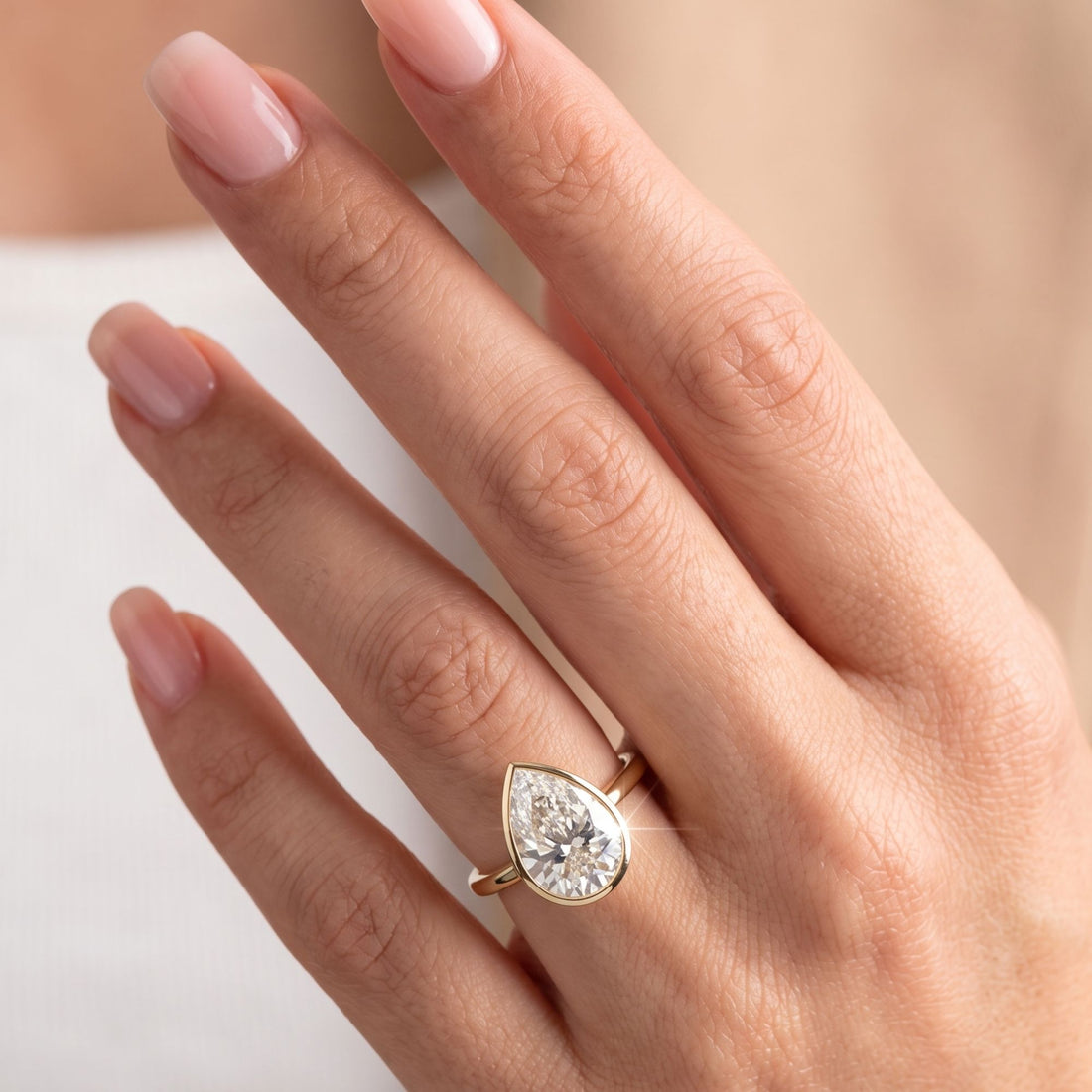 Pear diamond ring with open bezel ring setting.
