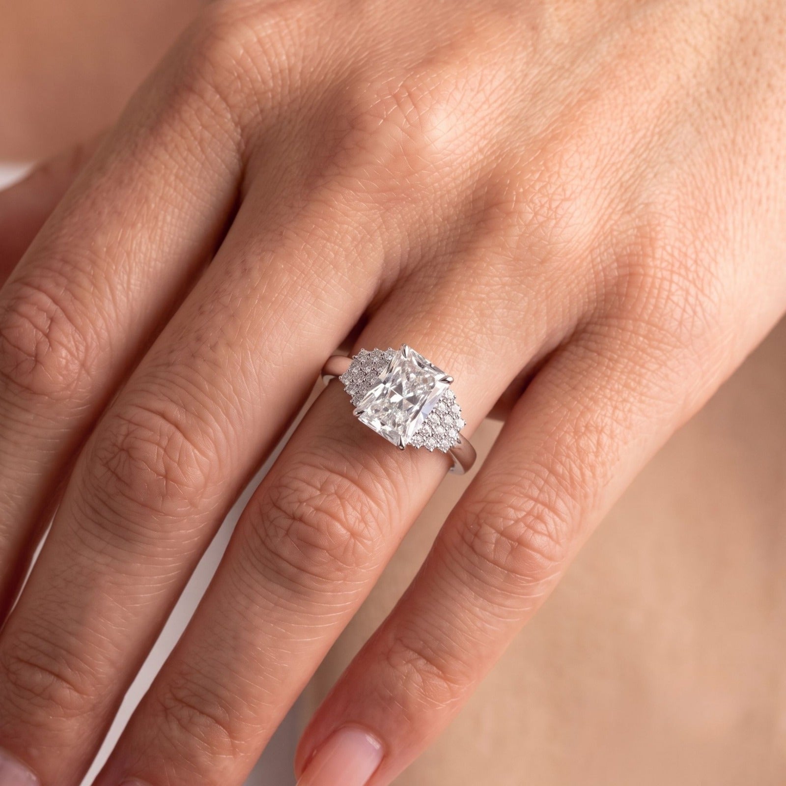 radiant cut diamond ring with side stone.