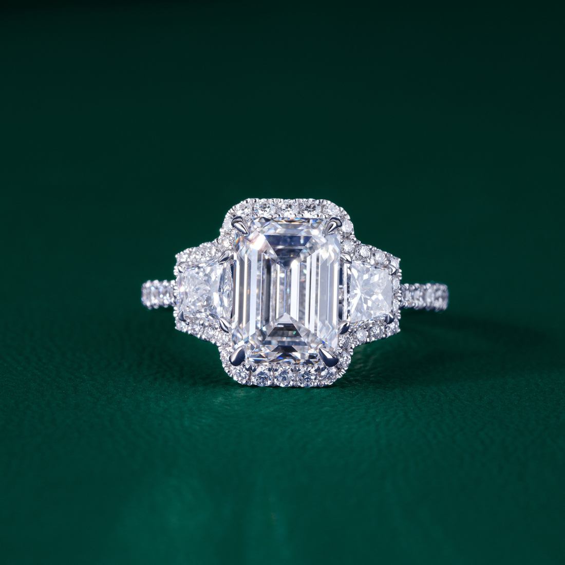 emerald three stone engagement ring with three stone diamond ring.
