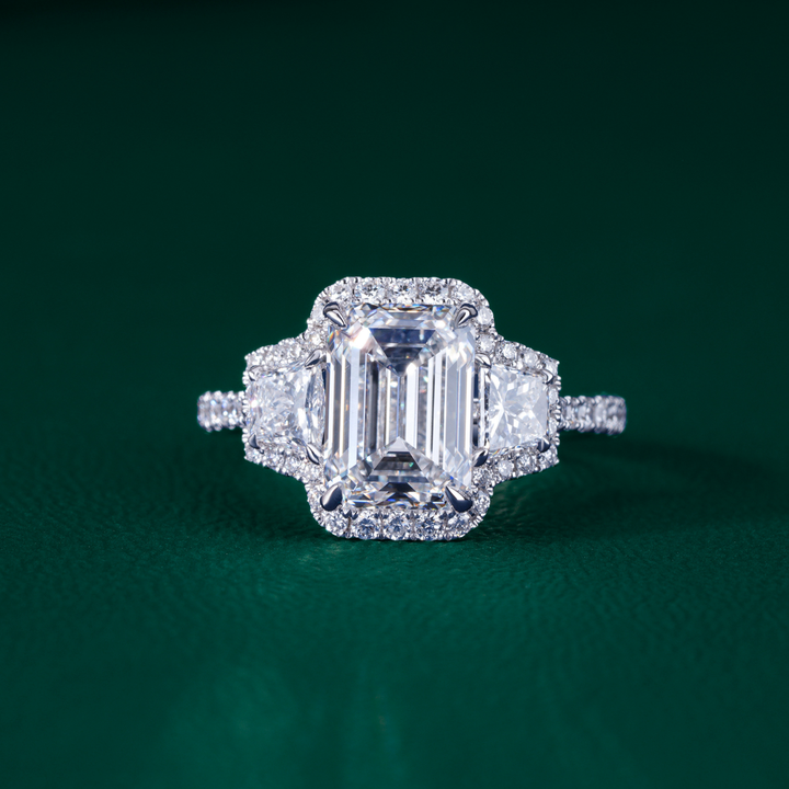 emerald three stone engagement ring with three stone diamond ring.
