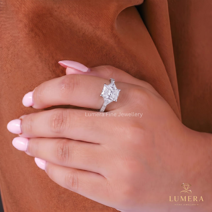 Radiant engagement ring with hide stone ring.
