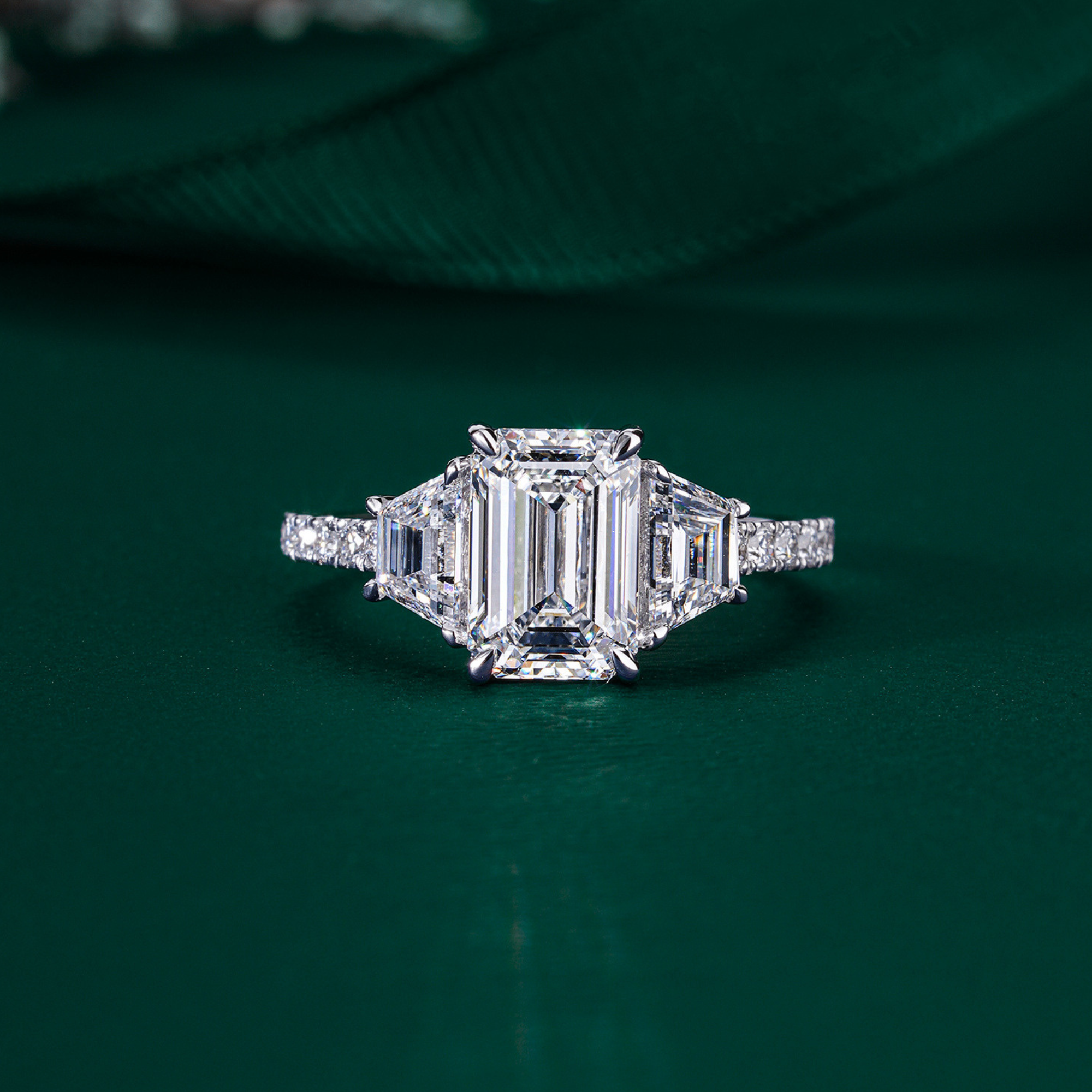  emerald diamond ring with trapezoid side stones.

