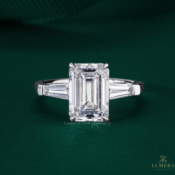 emerald engagement ring on tapered baguette side stones.
