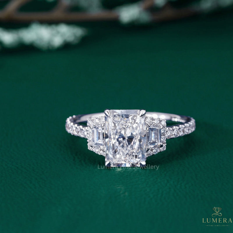 Radiant diamond engagement ring with trapezoid side stone.