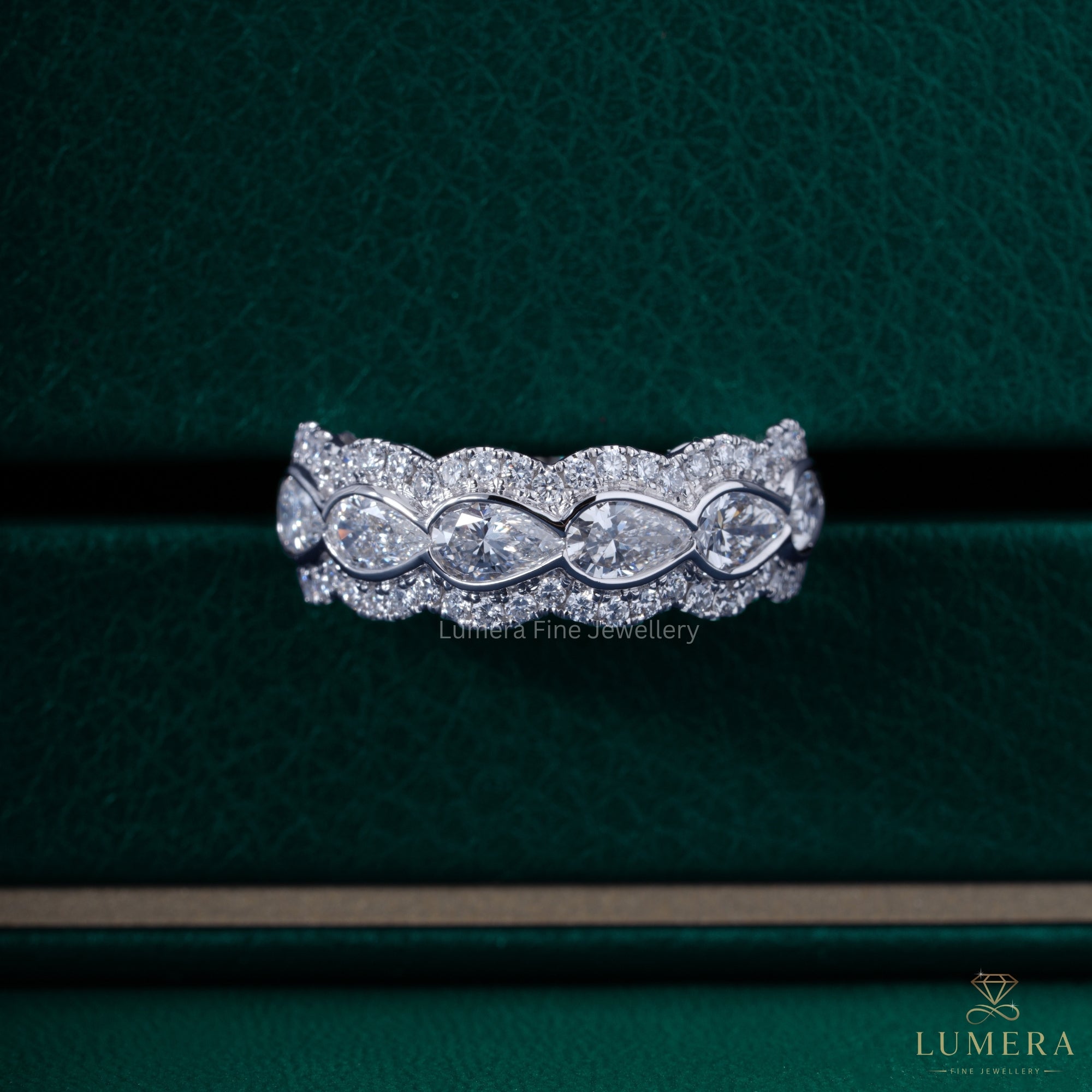 Halo wedding band with pear bezel set band.