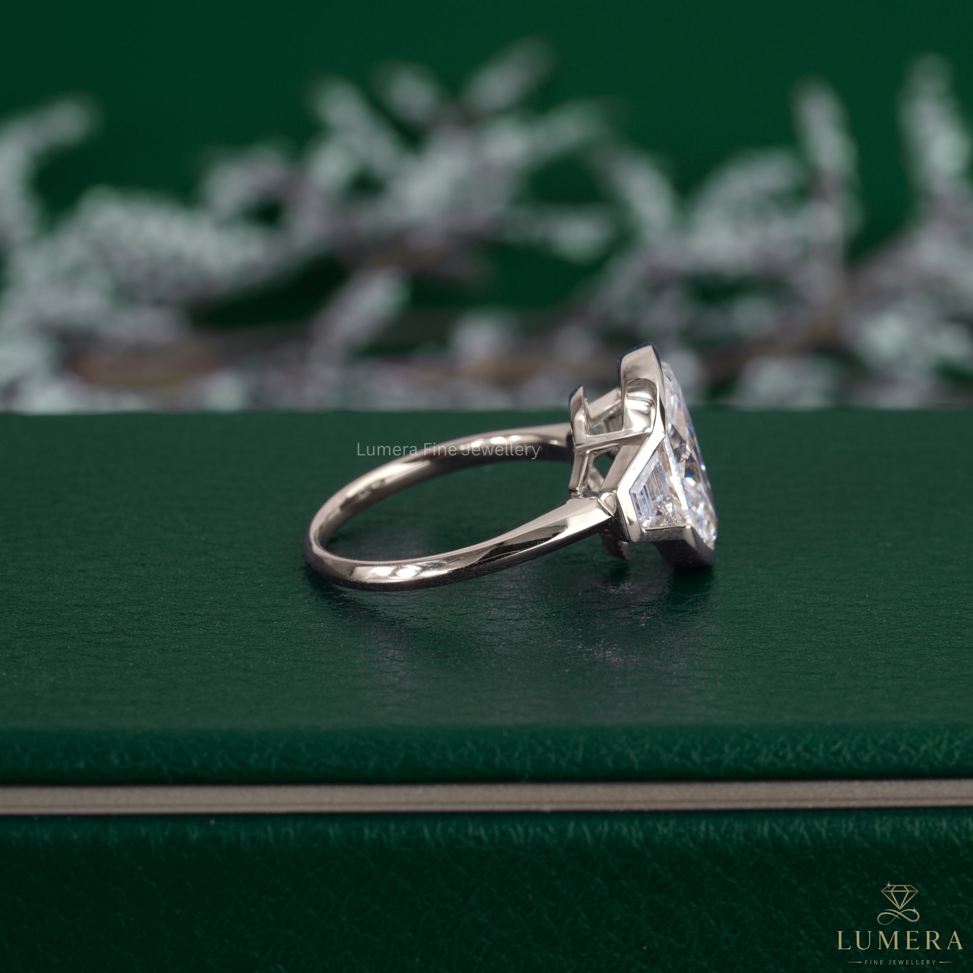 Oval cut diamond engagement ring featuring a trapezoid side stone.