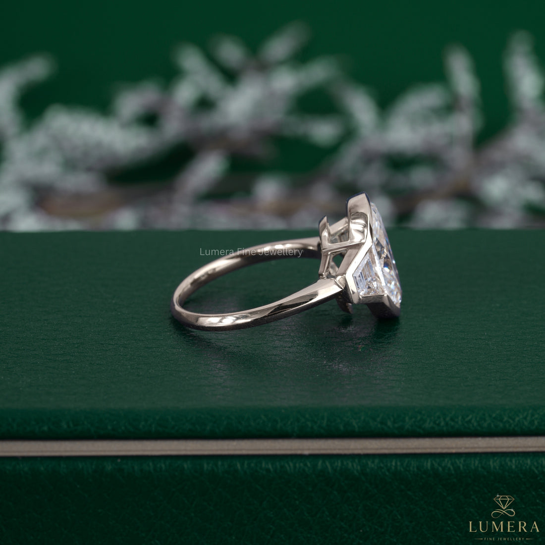 Oval cut diamond engagement ring featuring a trapezoid side stone.