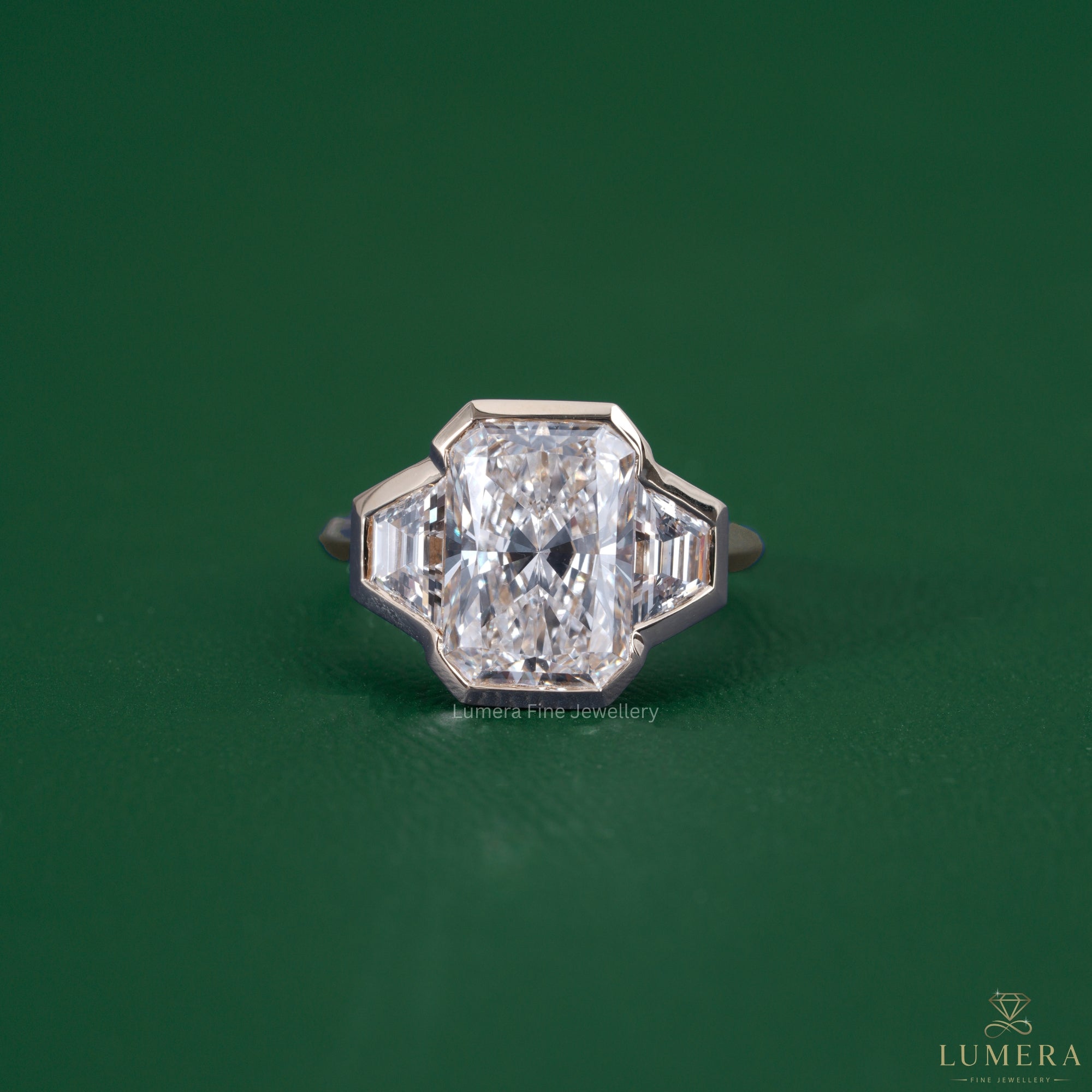 Radiant three stone engagement ring featuring a trapezoid side stone