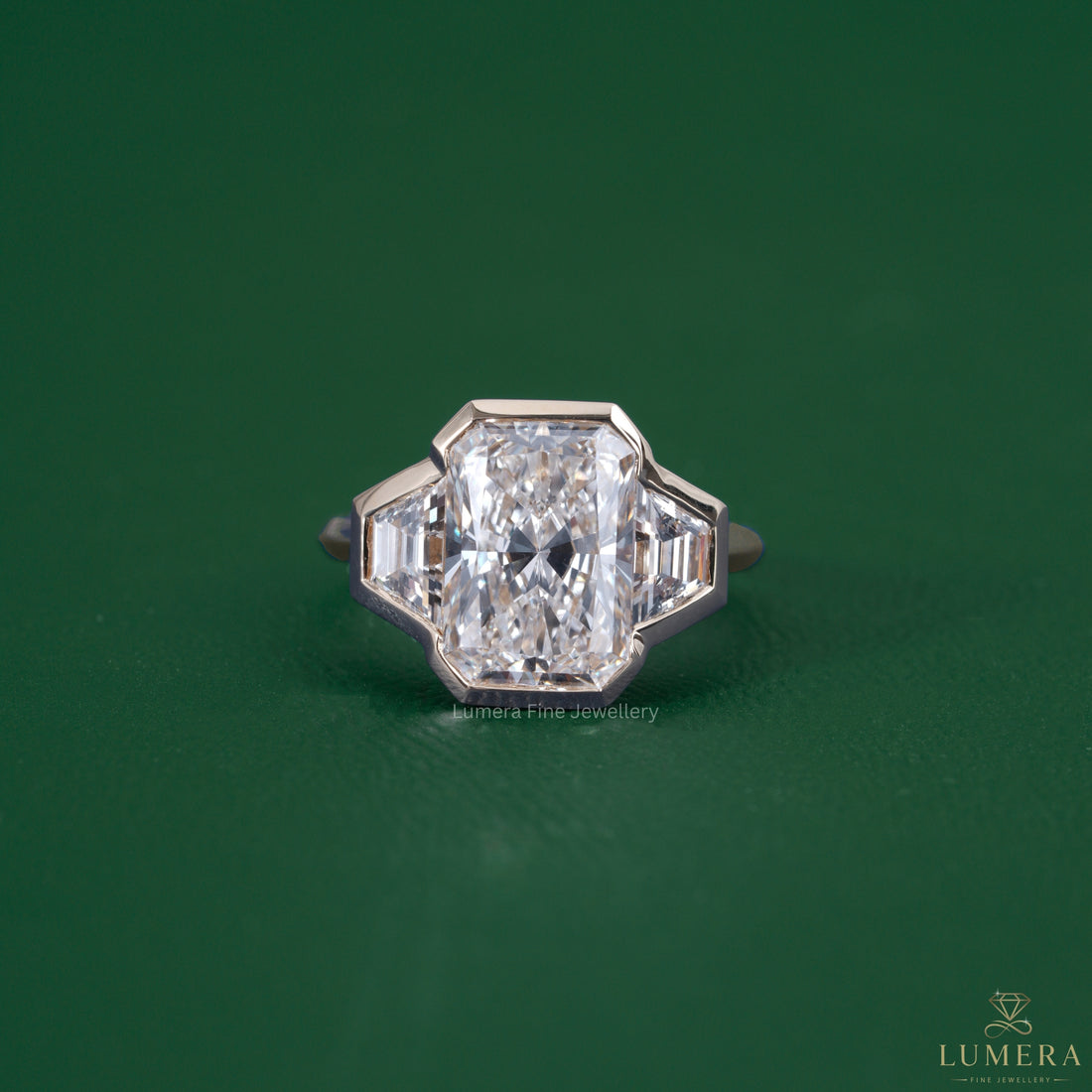 Radiant three stone engagement ring featuring a trapezoid side stone
