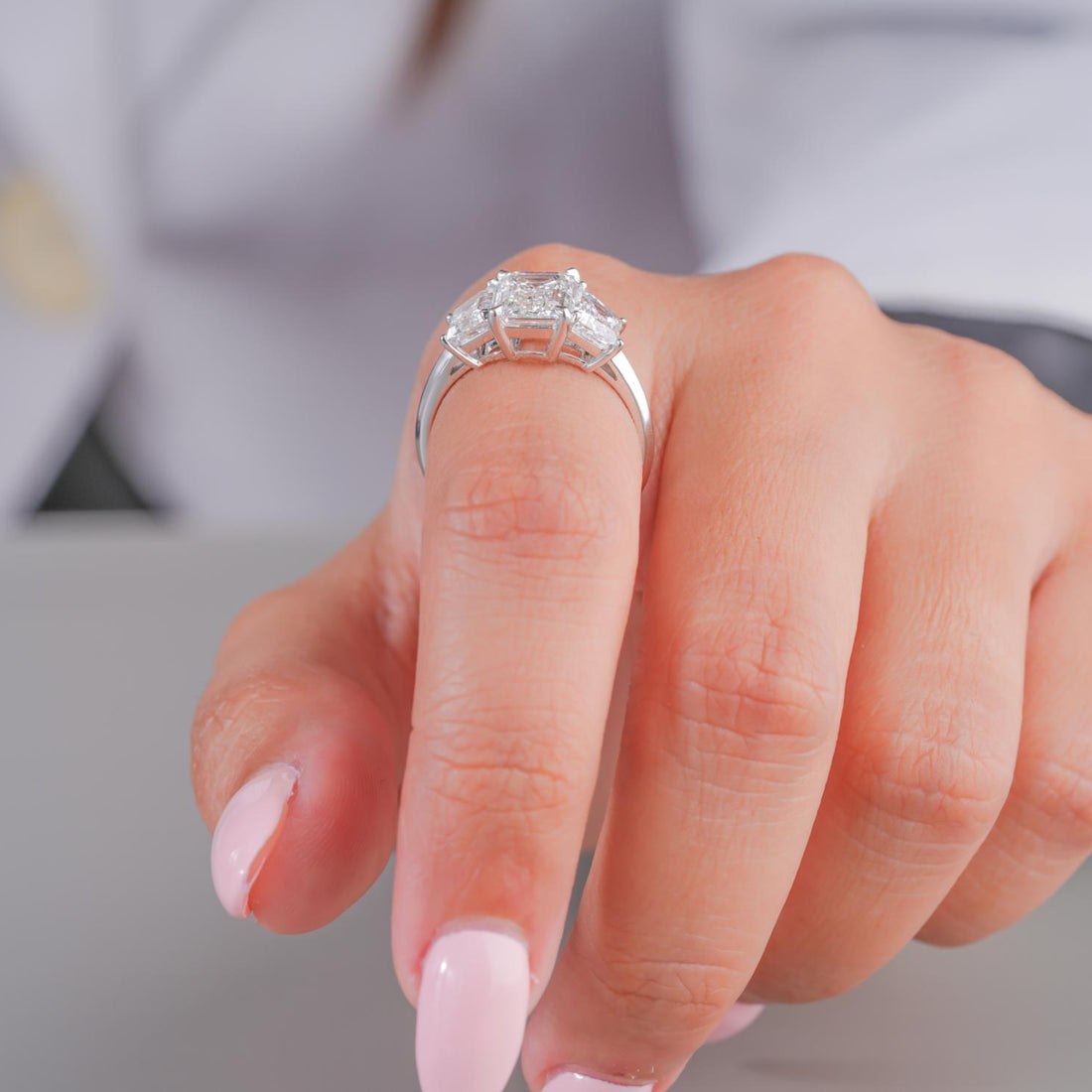 three stone emerald cut diamond ring with trapezoid side stones.
