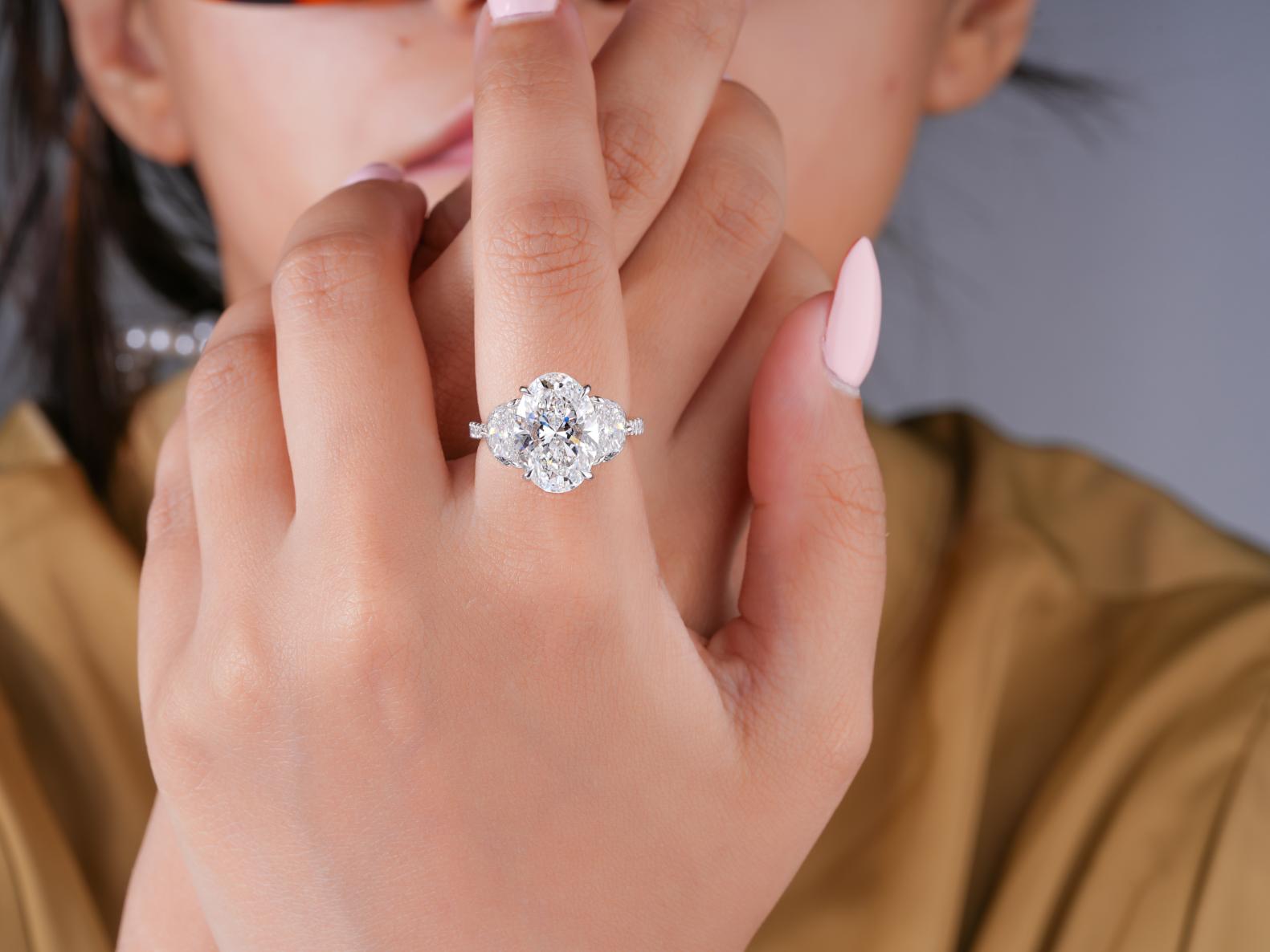 oval brilliant cut diamond ring with half moon cut side stones.
