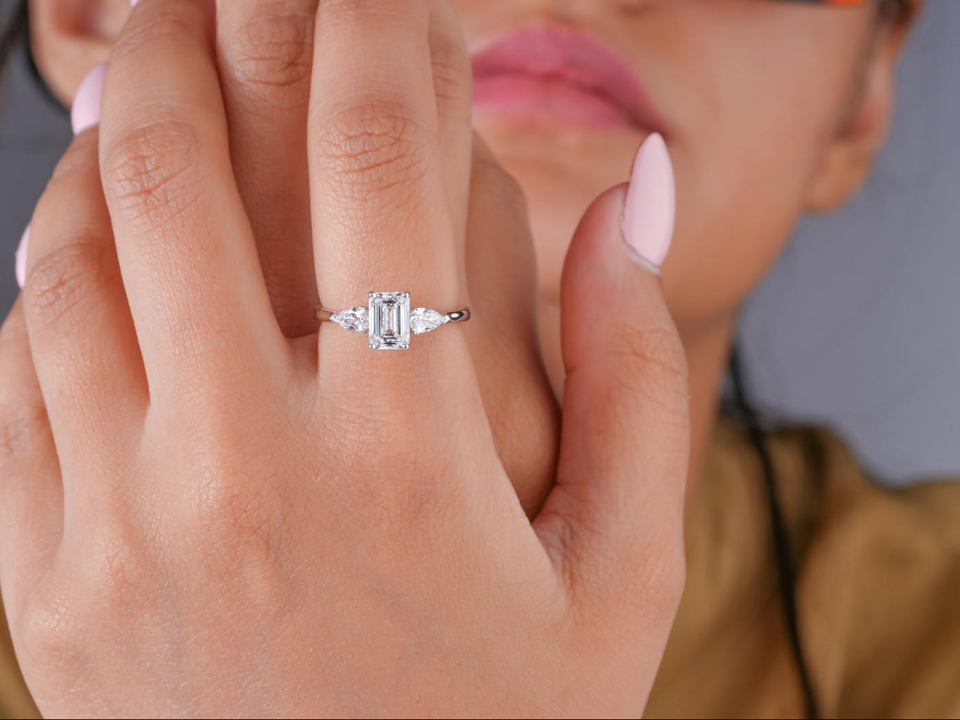 emerald cut engagement ring with pear cut side stone.
