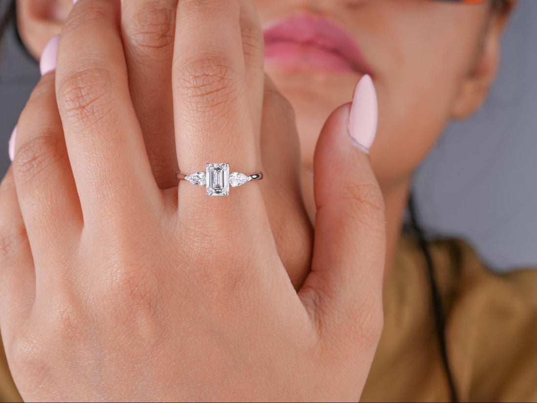 emerald cut engagement ring with pear cut side stone.
