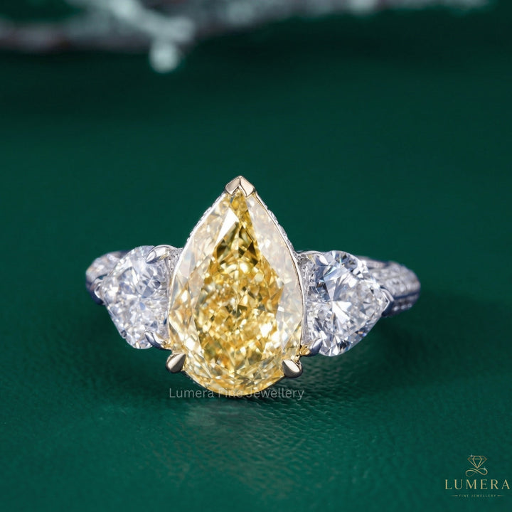 pear three stone engagement ring with heart diamond side stones.