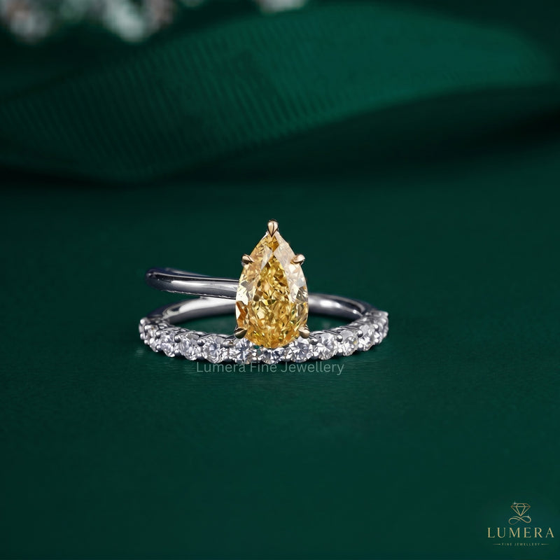 pear shaped engagement ring with yellow diamond ring.
