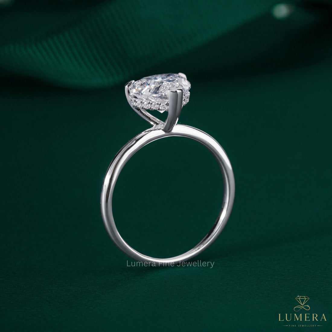 heart shaped engagement ring on hidden halo setting ring.
