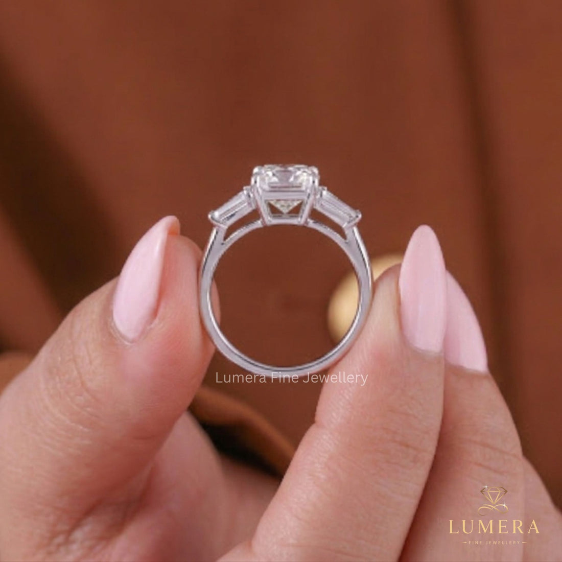 Tapered baguette side stones beside a square radiant cut ring.
