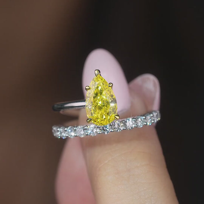 pear shaped engagement ring on pave setting band.
