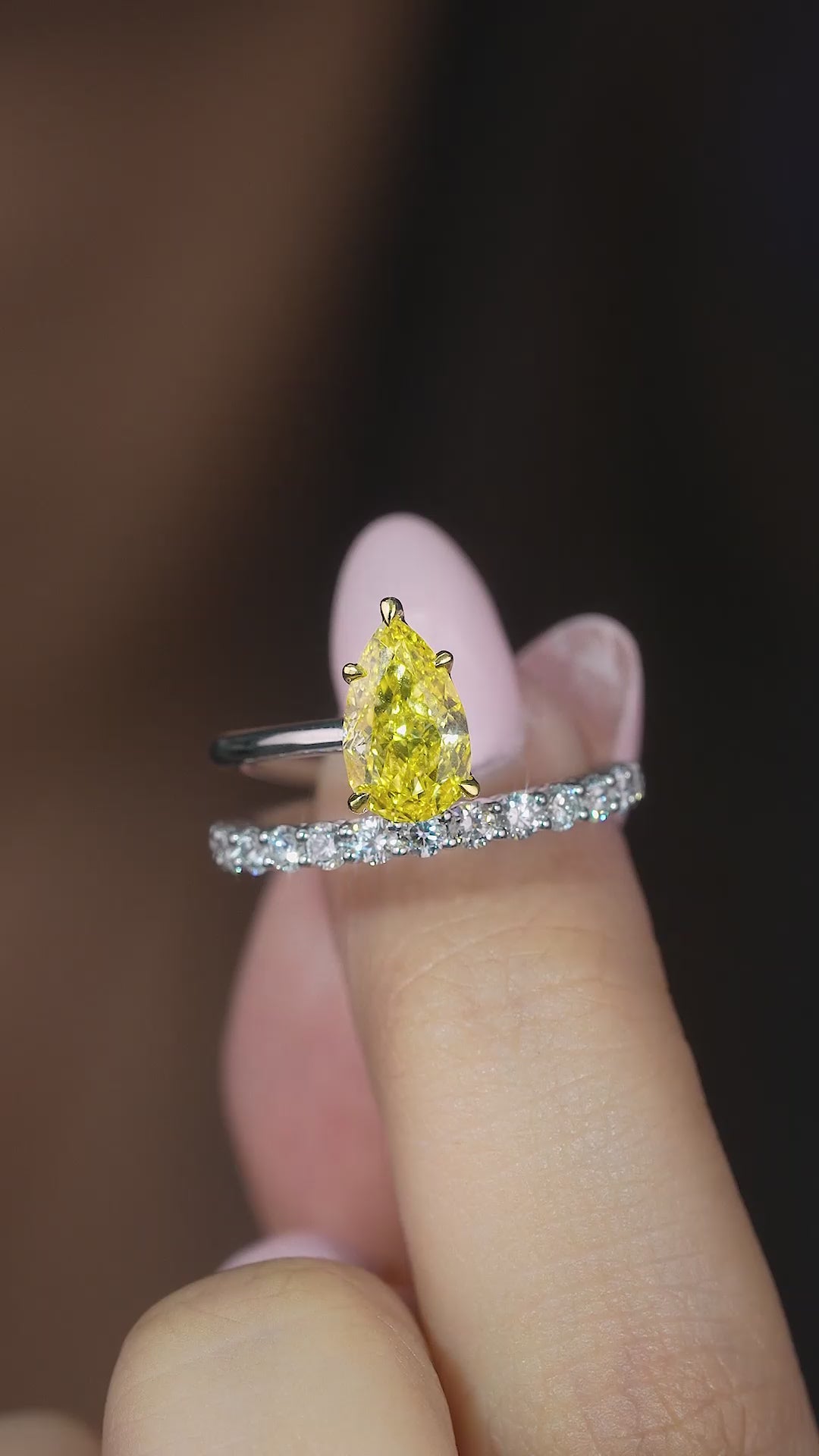 pear shaped engagement ring on pave setting band.
